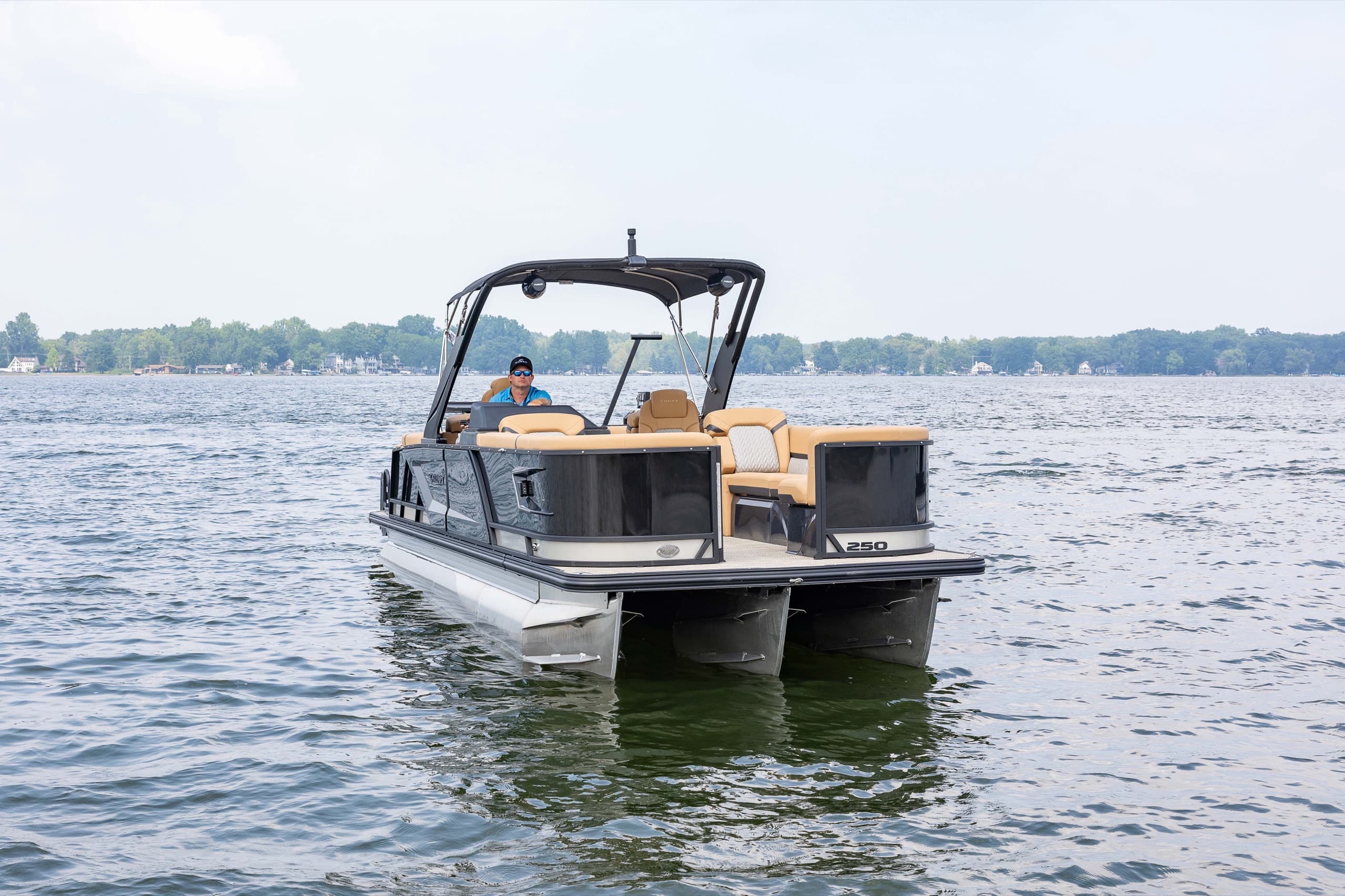 Pontoon boat at the helm with plush lounge seating, front three-quarter view