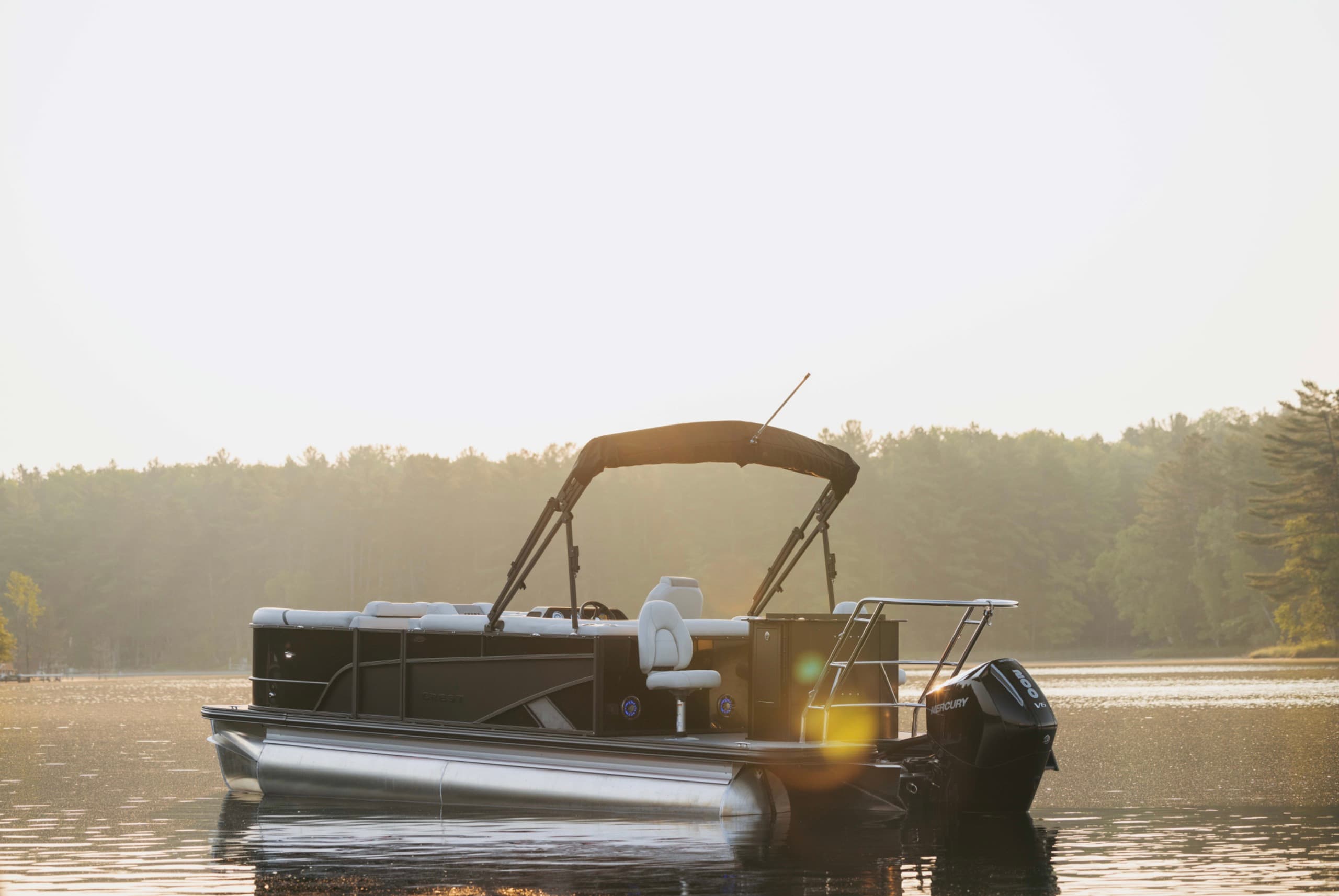 Black-hull 24-foot pontoon boat at golden hour with its V8 outboard