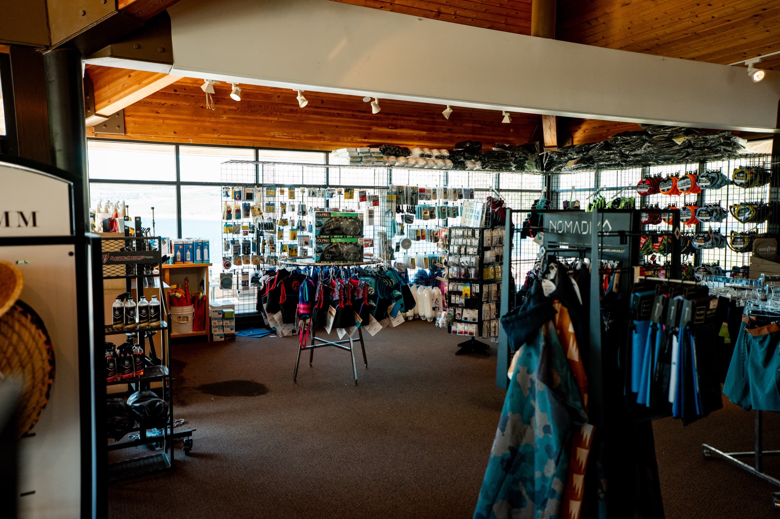 Inside the Jordanelle Marina pro shop — racks of watersports gear and life jackets with the reservoir visible through the windows