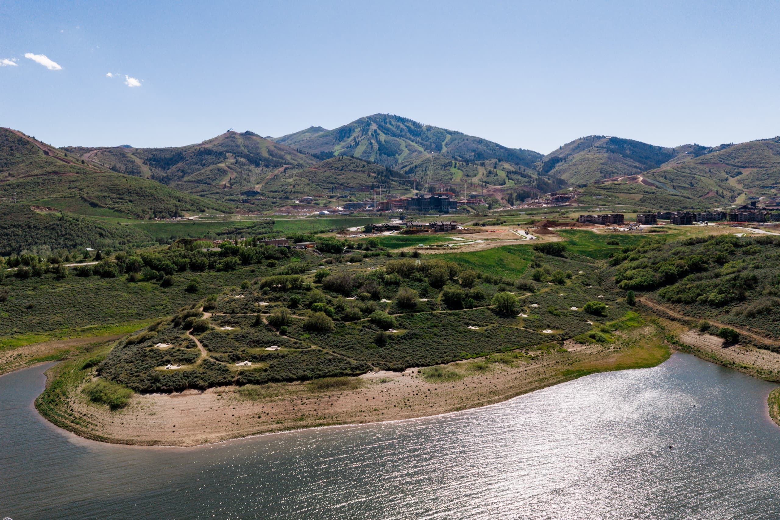 Aerial of Jordanelle Reservoir's green shoreline and the hills toward Park City